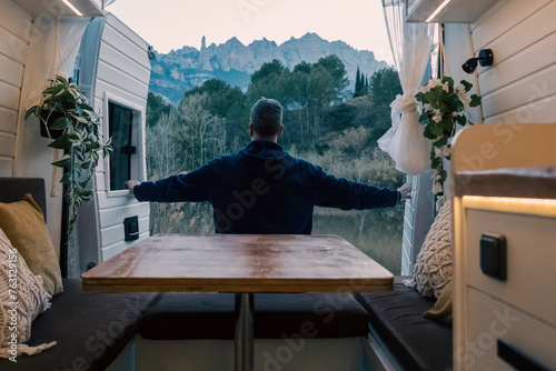 Cuadro en lienzo Mature man on vacation opening the rear doors of a camper van parked in front o