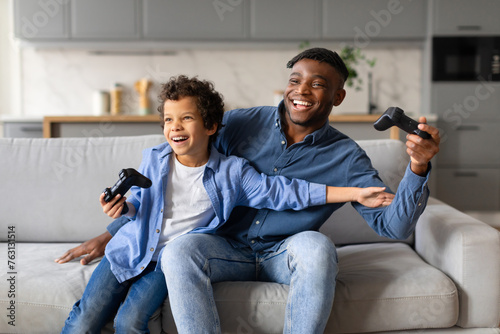 Father and son playing video games and laughing