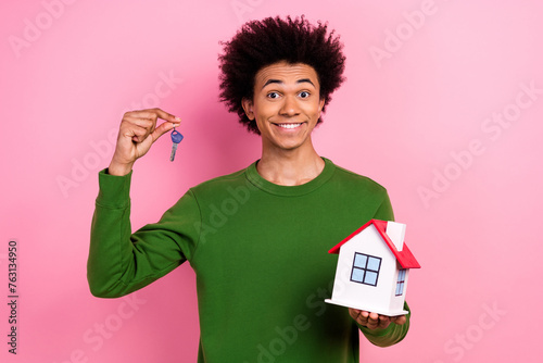 Photo of happy positive guy hold house building key advertising propperty isolated pastel color background photo