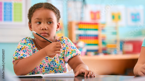 Photography Female Primary Or Elementary School Student At Desk In Classroom