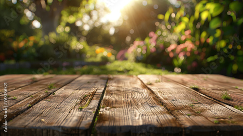 A rustic wooden table foregrounds a blur of colorful garden flowers bathed in sunlight.