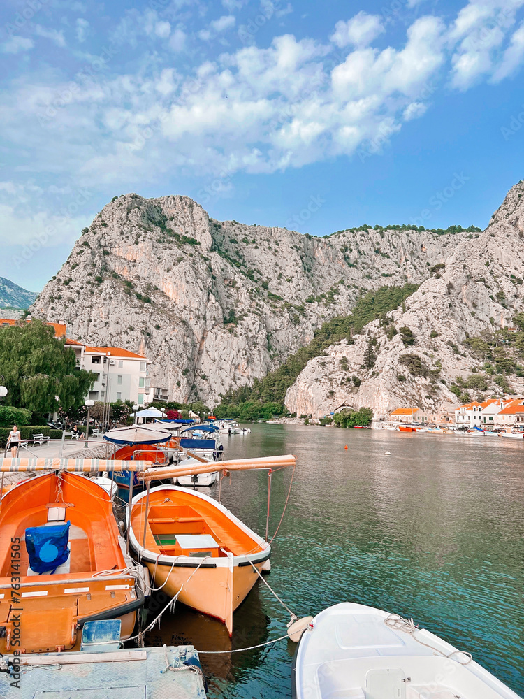 boat on the river bank and against the backdrop of mountains in the city of Omis Croatia