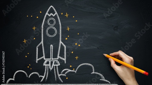a picture of a rocket on the blackboard with a hand holding a pencil