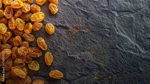 golden raisins on a dark stone background photo
