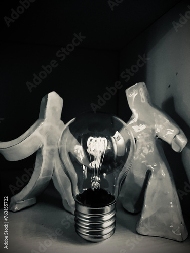 Foto concettuale di due omini in ceramica con al centro una lampadina  photo