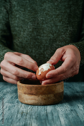 man peeling a brown boiled egg © nito