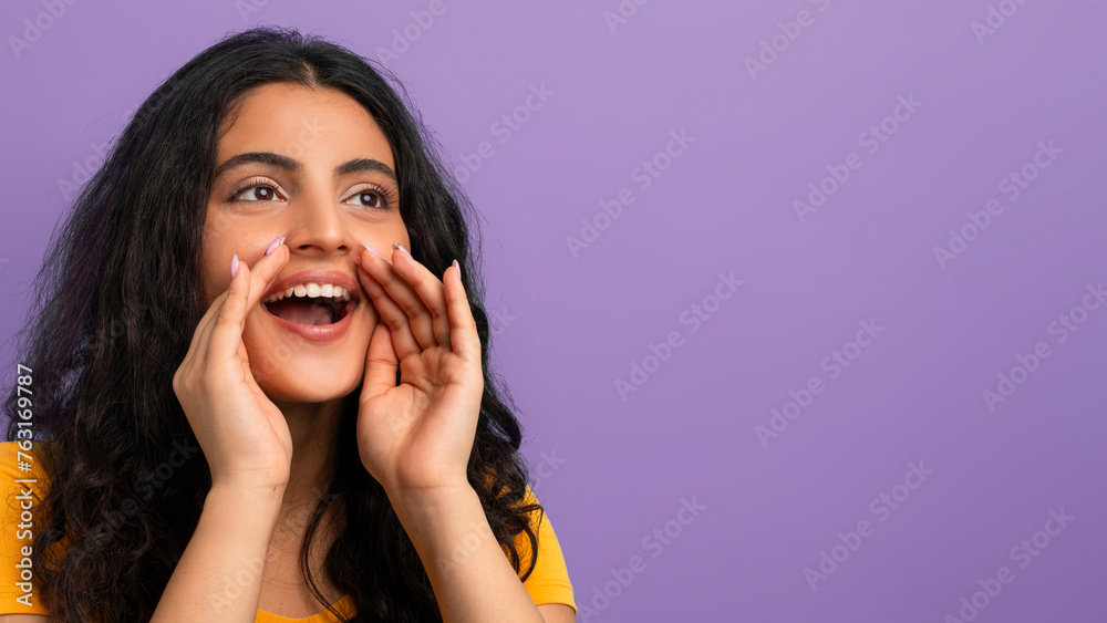 Young woman shouting with hands around mouth Young woman shouting with hands around mouth