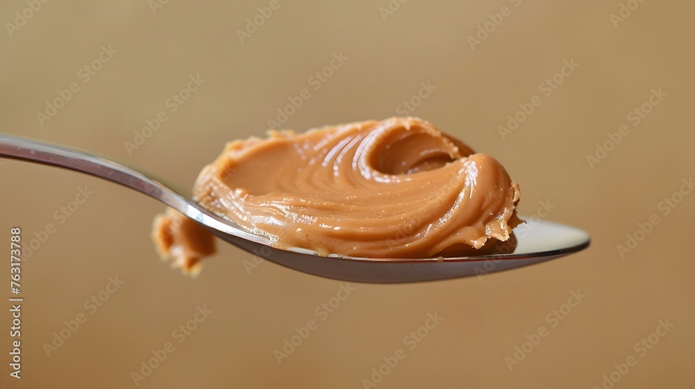 Fototapeta premium Peanut butter on a metallic spoon, traditional food