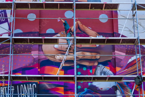 Experience the dynamic process of mural painting with these captivating photos. Witness artists transform building facades with bold strokes and vibrant colors. Perfect for showcasing urban creativity