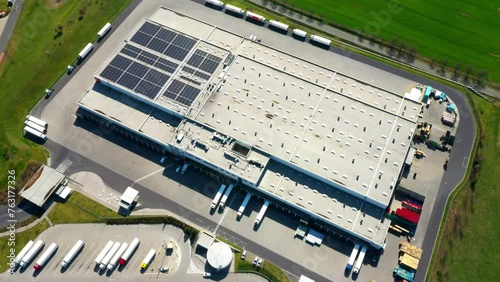 Industry with low carbon footprint. Industrial warehouses with solar panels on the roof. Technology park and factories from above.
