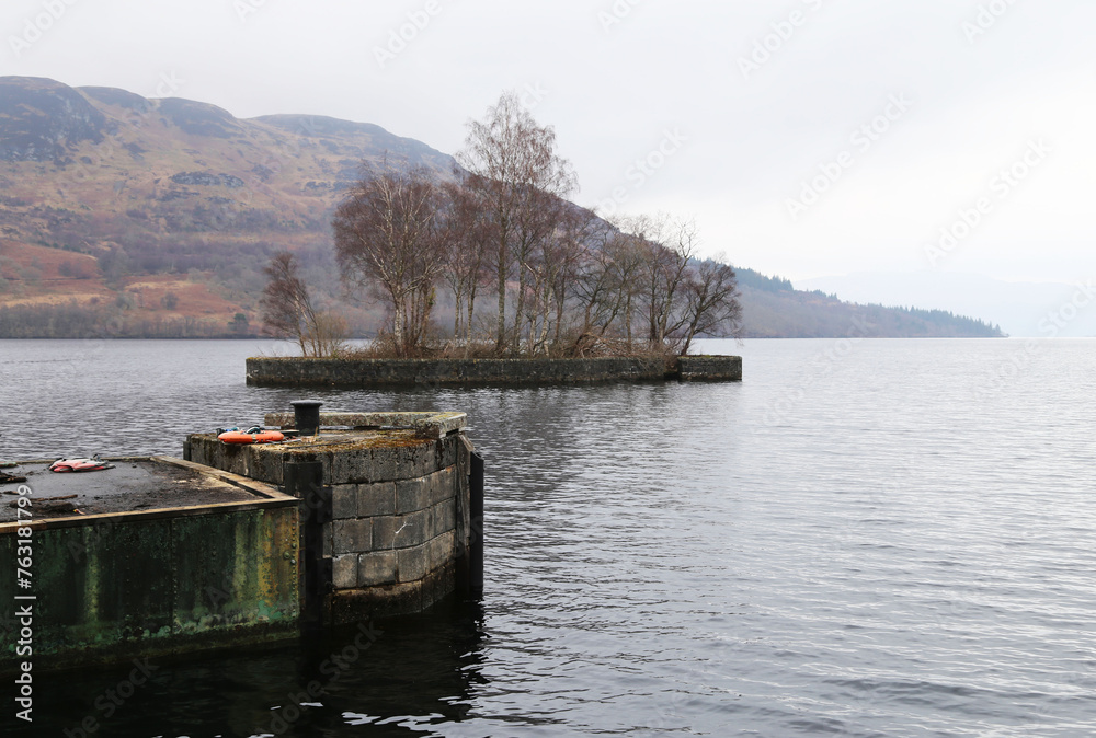 A view of Loch Katrine from Stronachlachar on a misty winter's day in The Trossachs, Stirlingshire, Scotland, United Kingdom. A view of Loch Katrine from Stronachlachar on a misty winter's day in The Trossachs, Stirlingshire, Scotland, United Kingdom.
