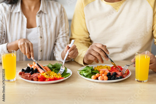 Unrecognizable couple sitting together at kitchen  have breakfast
