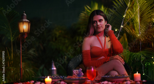 Indian Asian Hindu cute woman lady sitting chair drink wine hold juice glass outdoor house garden happy young female enjoy self love late night dinner party fun joy weekend break home park	