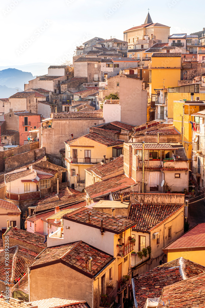 old vintage mediterranean mountain town with yellow and orange roofs, old tradirional streets, churches and amazing cloudy landscape on background