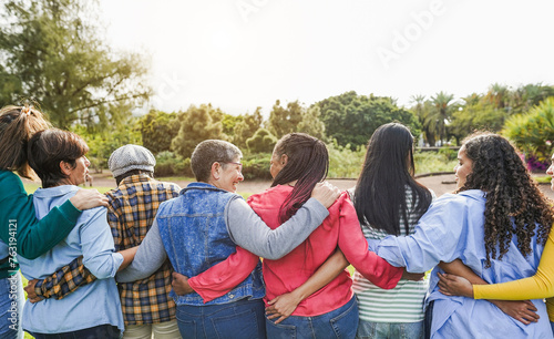 Multi generational women hugging each others - Female multiracial group having fun togheter outdoor - Firendship and people support concept - Main focus on african female head