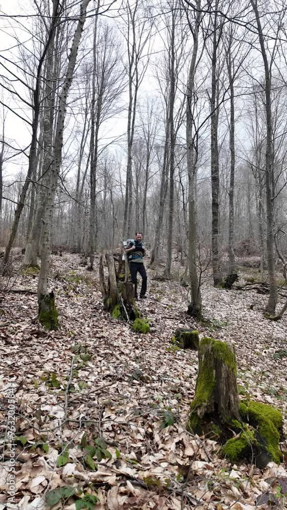Solo camper hiker walks in the middle of a forest with his camping backpack. Vertical. Solo camper hiker walks in the middle of a forest with his camping backpack. Vertical.