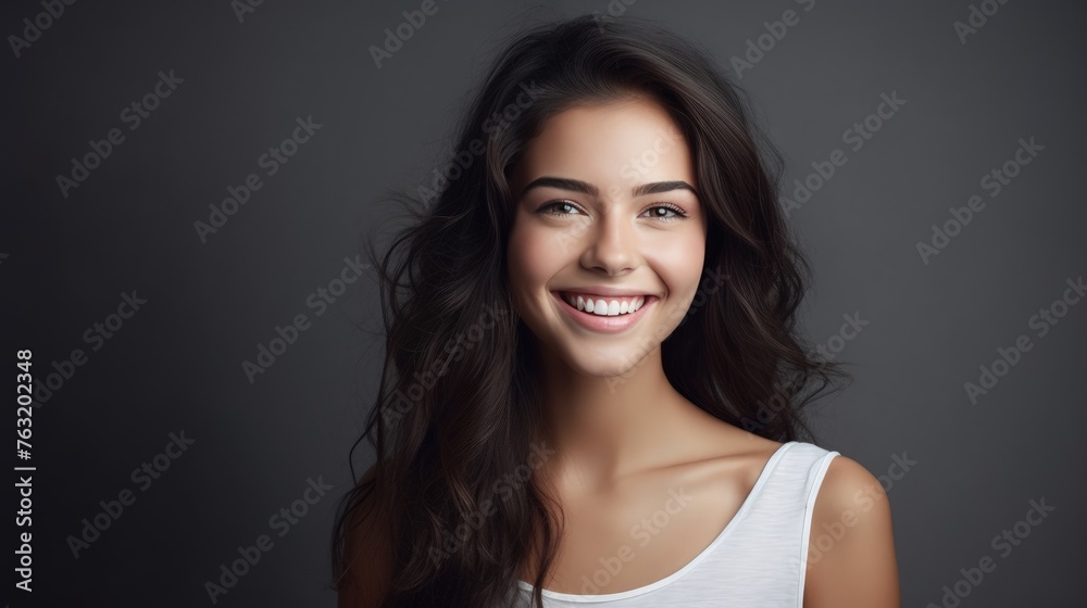 face of young woman with beautiful smile isolated on grey wall. face of young woman with beautiful smile isolated on grey wall.