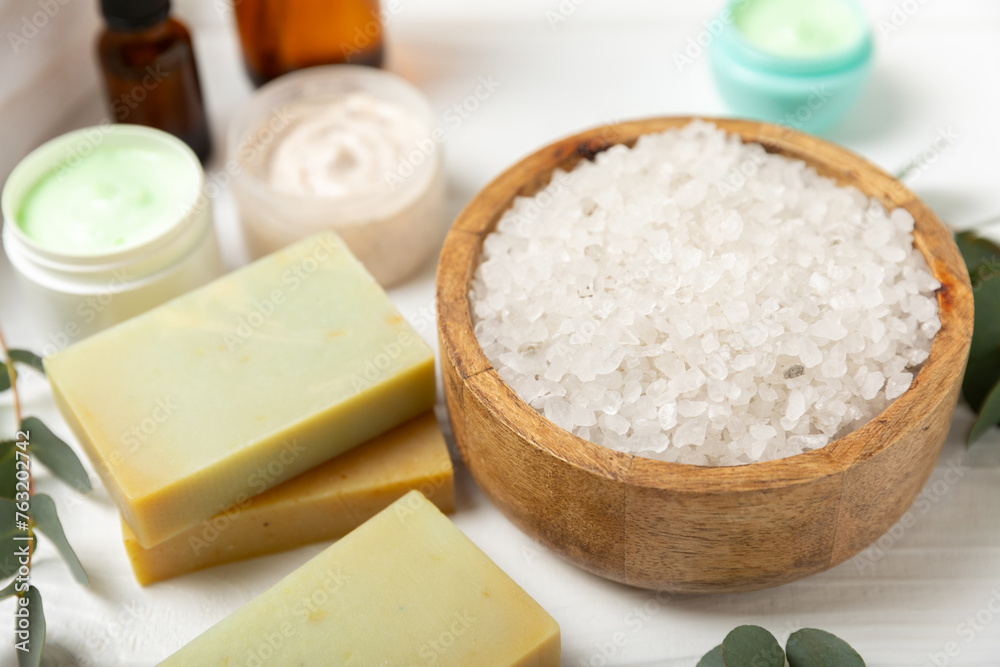 Beautiful spa composition on a wooden background with eucalyptus leaves. Beauty and fashion spa concept with body cream, scrub, mask, essential oil and sea salt.Cosmetic product. Copy space. Beautiful spa composition on a wooden background with eucalyptus leaves. Beauty and fashion spa concept with body cream, scrub, mask, essential oil and sea salt.Cosmetic product. Copy space.
