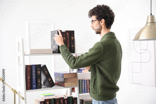 Male student taking book fr...