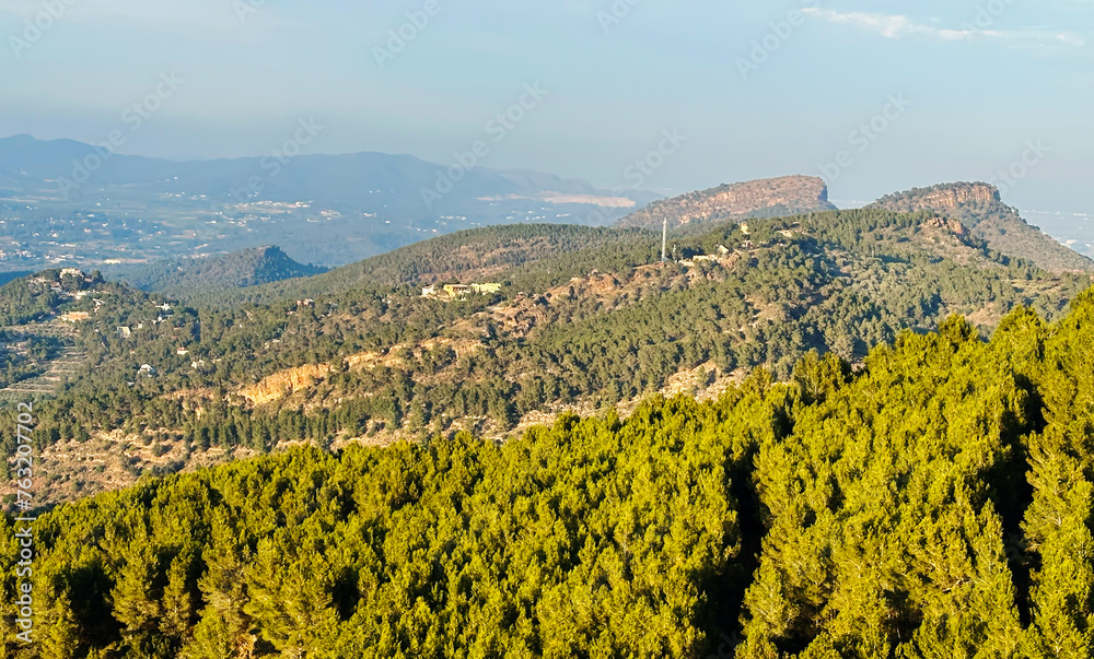 Mountains landscape, nature scenery. Green trees and huge cobblestones in mountain. View from Mola de Segart mountain, Sierra Calderona, Spain. Landscape of mountain valley. Hiking in canyon. Trekking