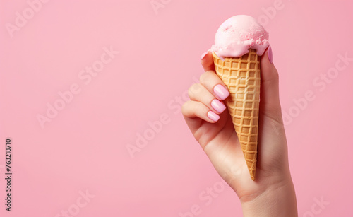 Hand Holding a Waffle Cone Ice Cream Scoop on a Pink Background