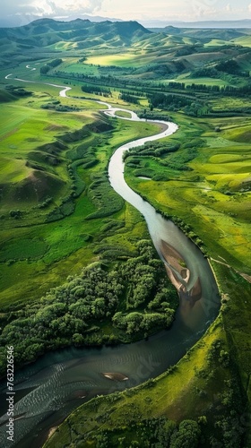Aerial view of a winding river through green hills