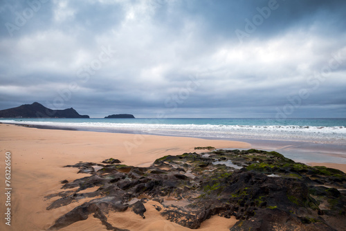 Dramatic coastal landscape with wet dark rocks. Beach of Porto Santo