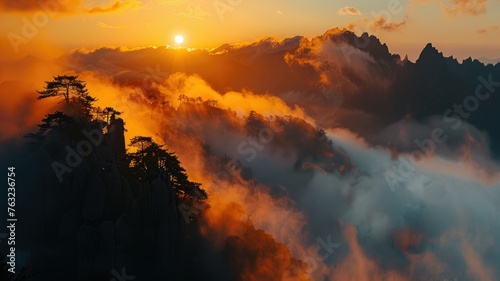 Sunset over misty mountains - Breathtaking landscape of a vibrant sunset sinking behind mist-covered mountain peaks
