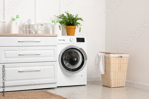 Interior of light room with washing machine and laundry basket © Pixel-Shot