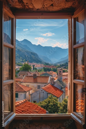 A view through an open window, revealing a scenic European village with cozy small houses and a stunning mountain backdrop