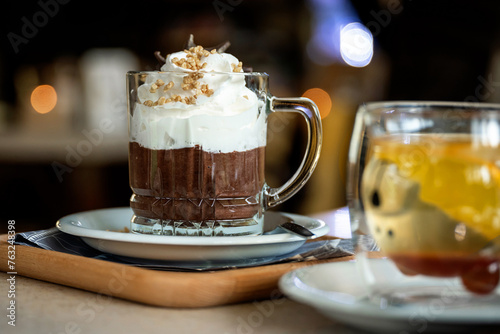 Hot chocolate with whipped cream and chopped nuts in a glass