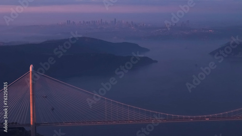 Aerial view of vehicles passing over Istanbul Yavuz Sultan Selim Bridge in sunrise light ships passing under it to enter the Bosphorus and its surroundings photo