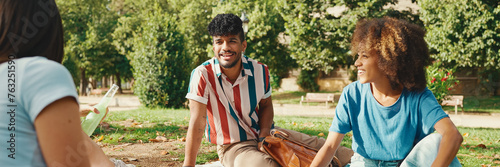 Happy smiling young multinational people at picnic on summer day outdoors. Friends have fun weekend together, relaxing in the park at picnic, Panorama