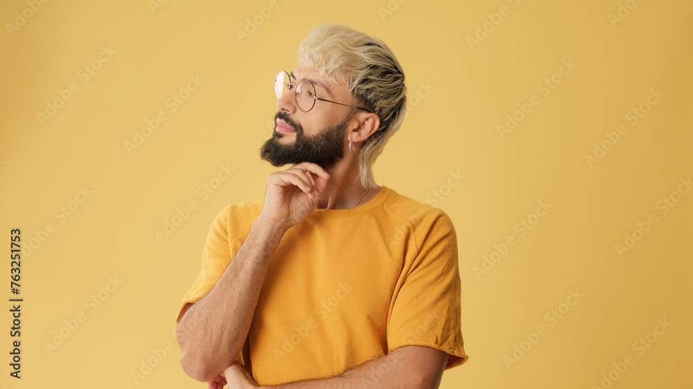 Guy with glasses, dressed in yellow T-shirt, dreams of something isolated on yellow background in studio Guy with glasses, dressed in yellow T-shirt, dreams of something isolated on yellow background in studio