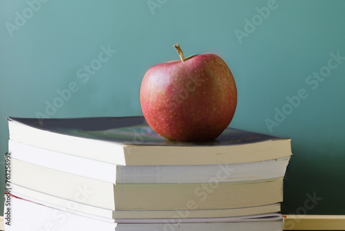 Old school eductation with a chalckboard a books with a red apple on top of the books photo