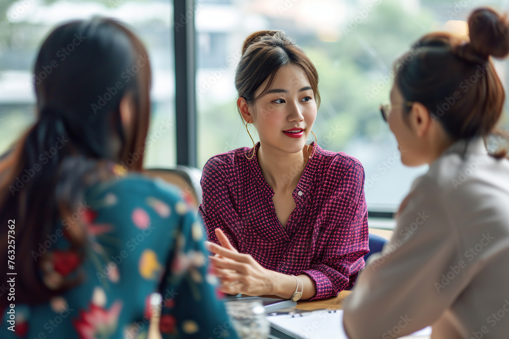 Group of Asian women having a conversation in the office