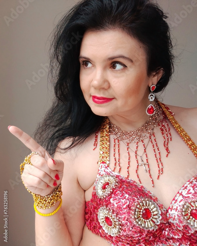 Bilde på lerret A dancer in a red suit is dancing an oriental dance on a white background