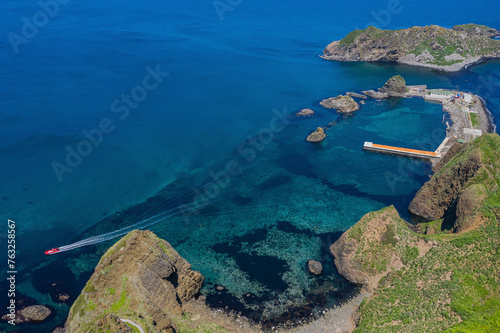 Aerial view of Moneron island in Sahalin oblast with beautiful sandy beach, clear blue water, and boats, Nevelsk, Sakhalin, Russia. photo