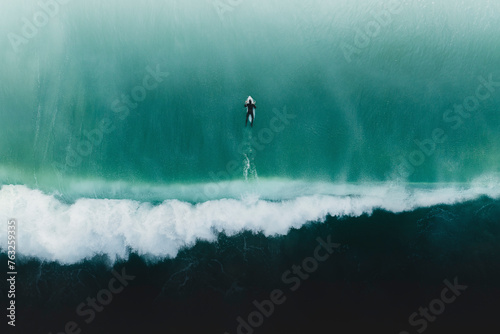 Aerial view of a surfer immersed in the colors of the sea in Peniche, Portugal. photo
