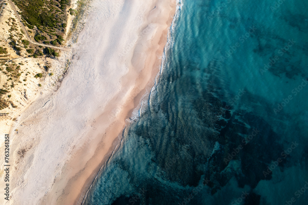 Aerial view of a white sandy beach from above with calm turquoise blue water, Port Willunga, South Australia, Australia. Aerial view of a white sandy beach from above with calm turquoise blue water, Port Willunga, South Australia, Australia.