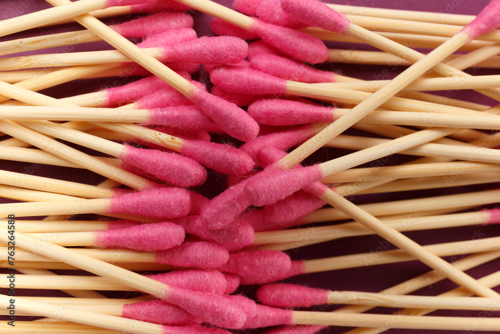 Bamboo cotton swabs buds sticks on a purple background, close-up