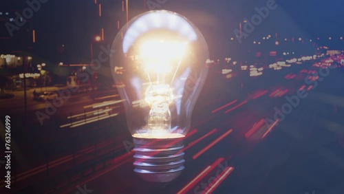 A flashing light bulb against the backdrop of a night city in blur. Modern world speed concept. Cg footage photo
