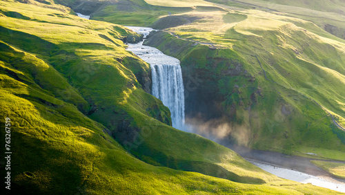 Aerial drone view of Skógafoss waterfall during sunrise in summer time, Southern Iceland.
