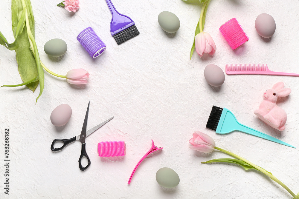 Frame made of hairdressing accessories with tulips, Easter eggs and bunny on white grunge background