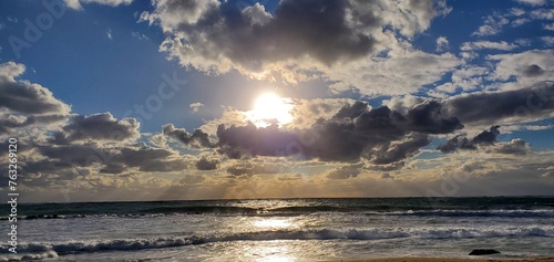 Foto Sunset at the beach with the sun peeking through
