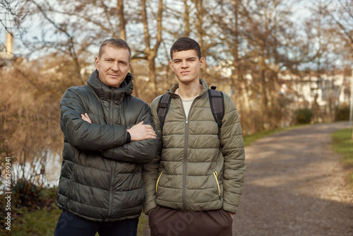 Father-Son Bond: Handsome 40-Year-Old Man and 17-Year-Old Son Standing Together in Winter or Autumn Park.