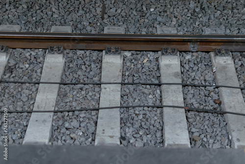 Close-up - railway track metal rails on concrete sleepers, lie on fine gray gravel