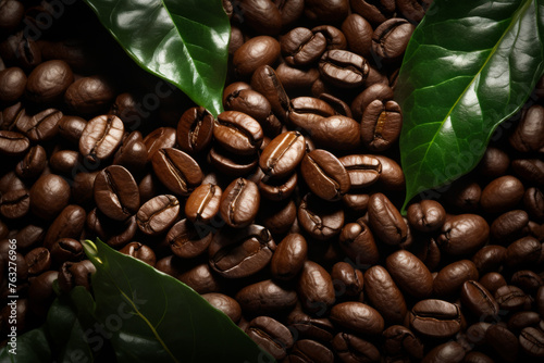 Pile of coffee beans with leaf next to it.