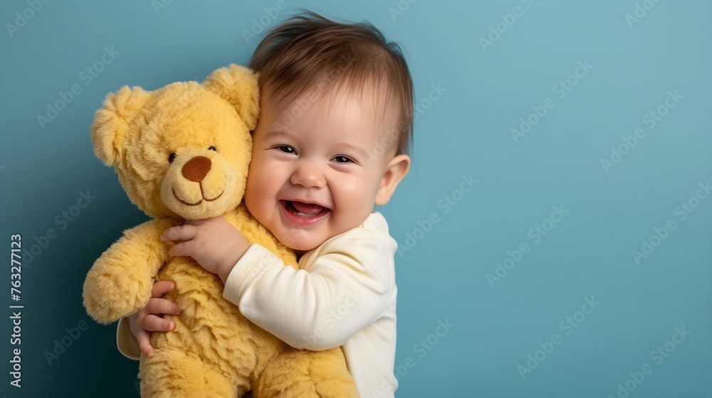 a baby holding a teddy bear in his arms on a grey background a baby holding a teddy bear in his arms on a grey background