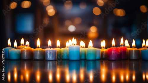 Group of blue and pink candles are lit in row.